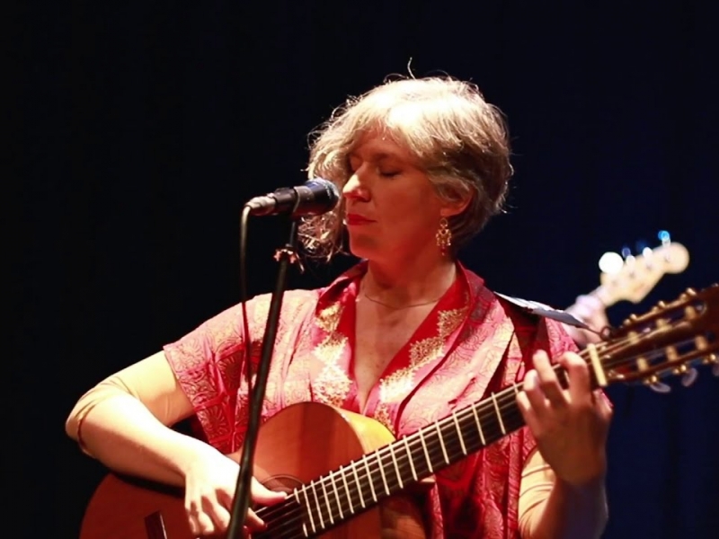 Carolina Guttmann tocando guitarra y cantando. 