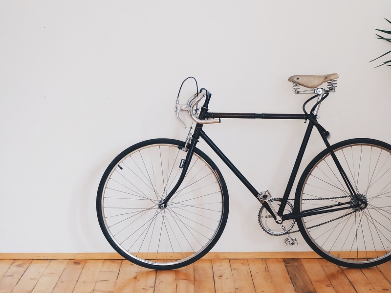 Bicicleta parada enfrente de una pared blanca. 