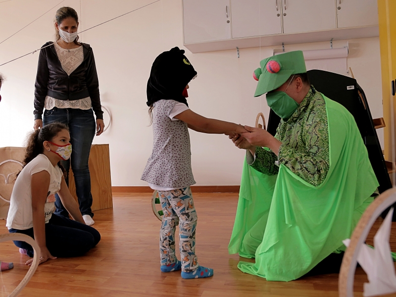 Artista del Programa Nidos que juega con niñas y niños.