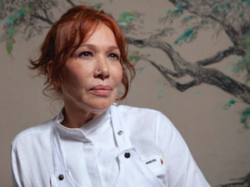 Mujer cocinera con un árbol de fondo 