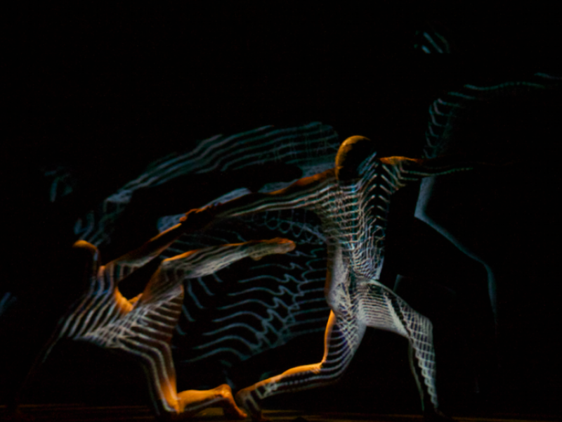 Personas danzando dejando un estela de luz 