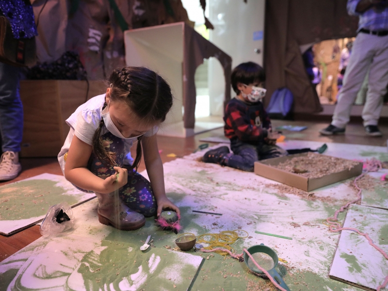 Niña y niño jugando con materias y materiales en ambientación efímera