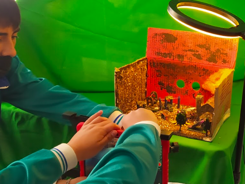 Niños organizando una maqueta con un foco de luz 