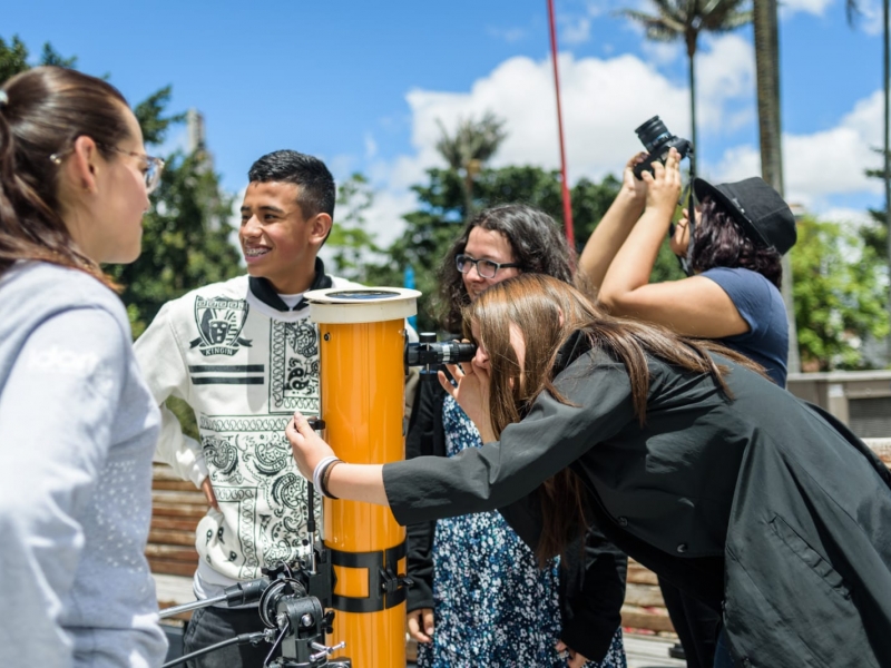 Personas al aire libre en actividad con telescopio