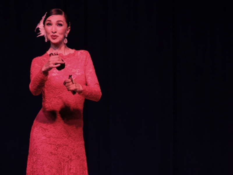 Mujer danzando en escenario con castañuelas