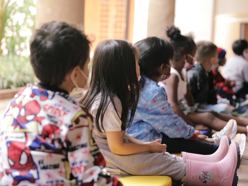 Fila de niños sentados en el piso