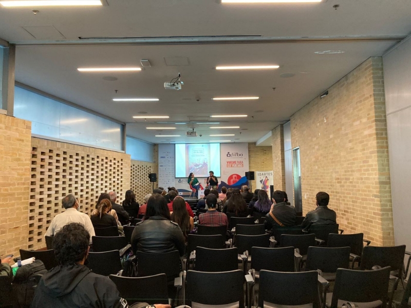 Salón con gente sentada escuchando una conferencia