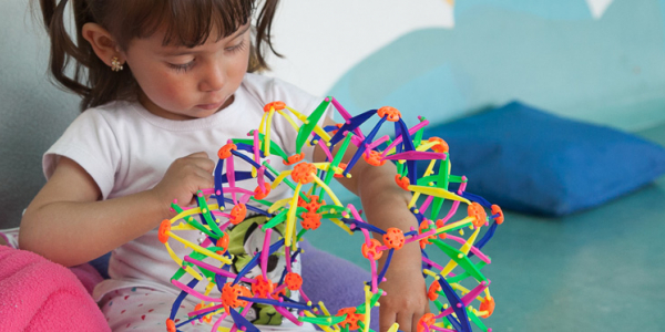 Niña jugando con estrella de colores vivos.