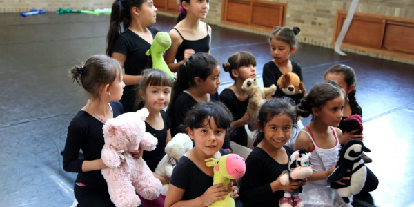 Niñas con muñecos de peluche y tela en recinto cerrado