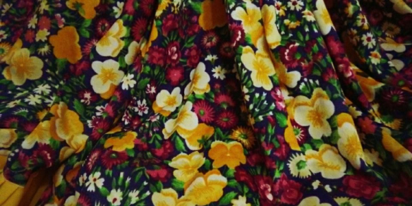 Falda de flores con las letras de la obra en un collar de cuadritos
