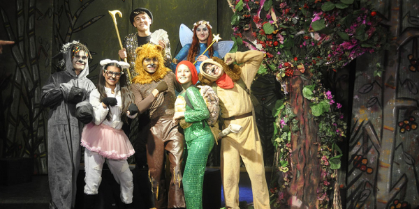 Grupo de actores disfrazados de animales posando en el escenario