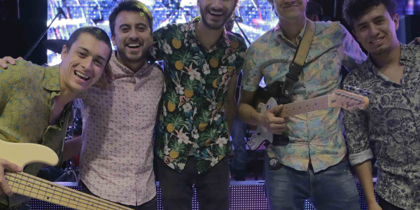 Hombres frente a una pantalla posando para la cámara