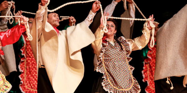 Bailarines con trajes típicos y ruanas en escena