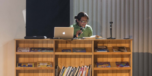 Hombre en una bibliotreca leyendo para el público