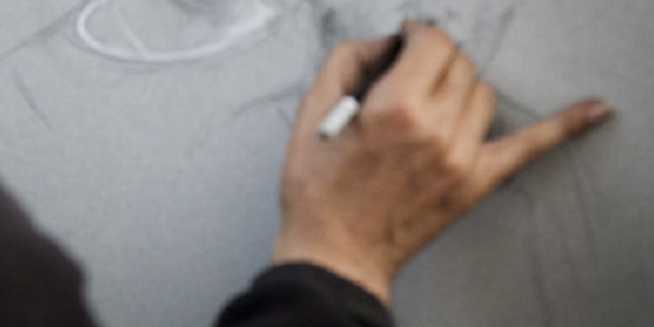 Mano dibujando sobre papel blanco