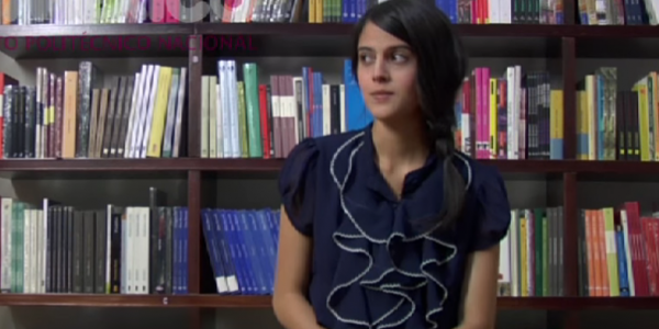 Mujer sentada frente a una biblioteca