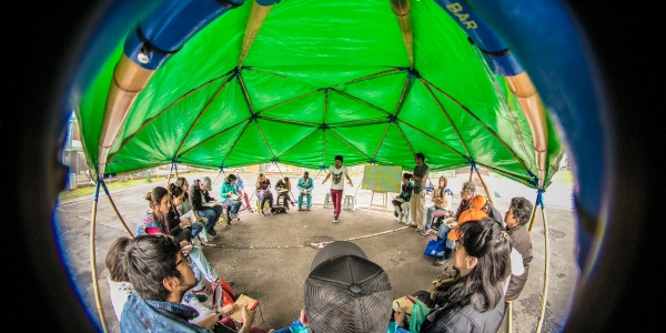 Imagen circular de niños participando en una actividad recreativa al aire libre