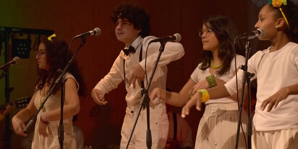 Grupo de jóvenes en escena vestidos de blanco