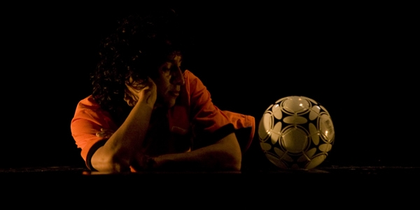 Actor en escena mirando una pelota de fultbol