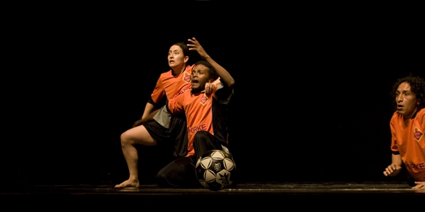 Actores en escena vestidos de jugadores con pelota de futbol