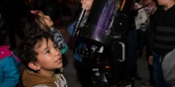 Personas participando de un ejercicio de observación nocturna con telescopio