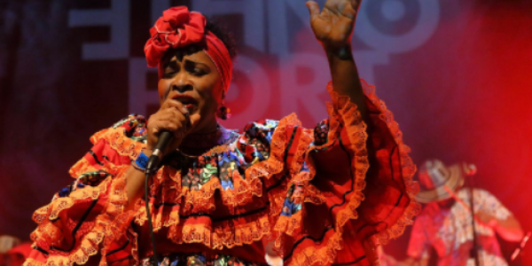 Fotografía de Lina Babilonia cantando con la mano arriba