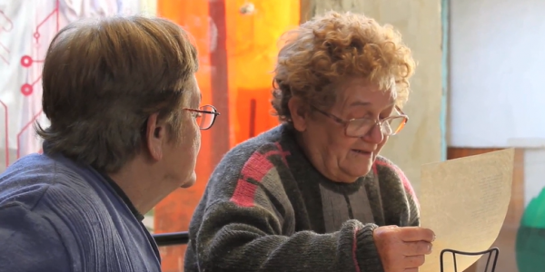 Foto de dos Mujeres con gafas que leen una hoja de papel 