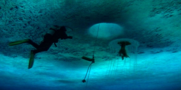 Escena de la película La salvaje y azul lejanía. Buzo debajo del agua azul. 