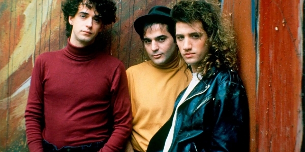 Tres integrantes de Soda Stereo enfrente de una pared. 