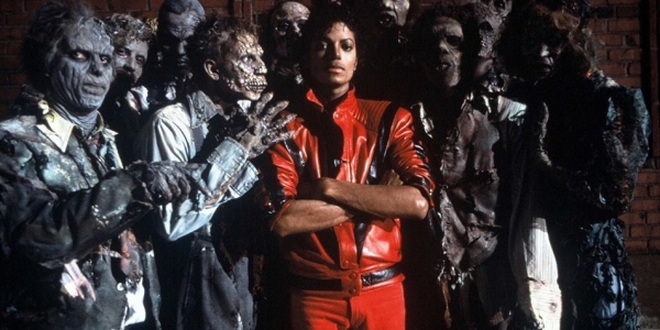 Michael Jackson en traje rojo entre varios zombies en famoso video de Thriller. 