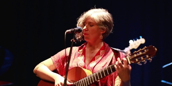 Carolina Guttmann tocando guitarra y cantando. 