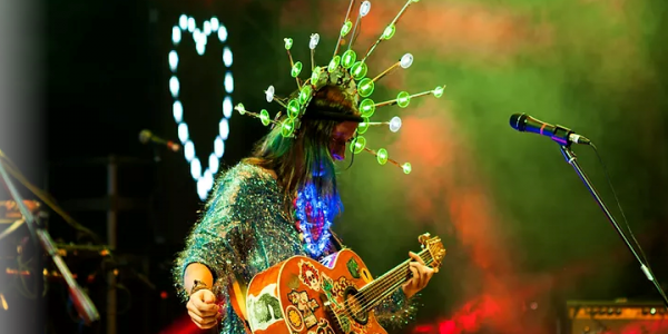 Andrea Echeverri con su guitarra llena de calcomanías en escena 