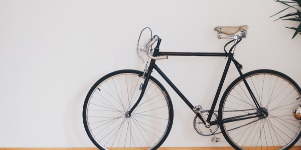 Bicicleta parada enfrente de una pared blanca. 