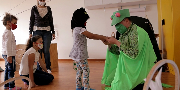 Artista del Programa Nidos que juega con niñas y niños.