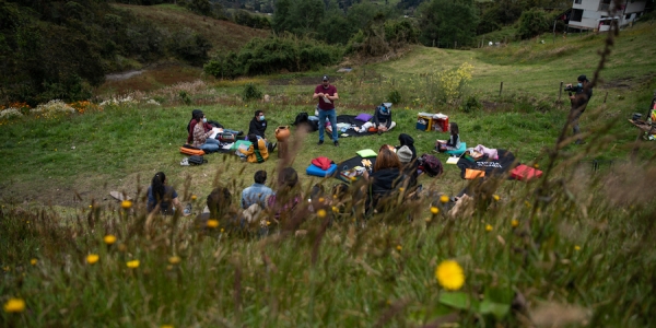 Jóvenes y niños en un campo hablando con mediadior del Planetario. 