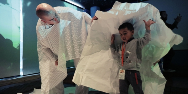 Artista del Programa Nidos jugando con un niño en primera infancia