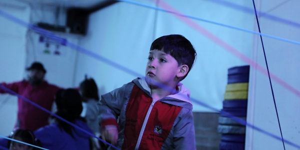 Niño jugando con hilos de color