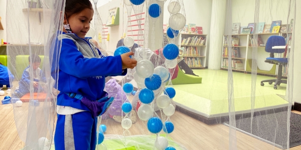 Niña en primera infancia jugando con pelotas