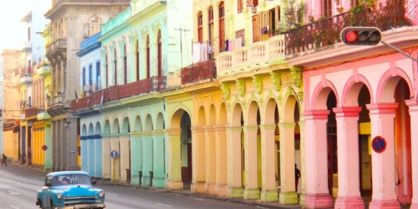 Fotografía de casas caribeás de colores y carro antiguo