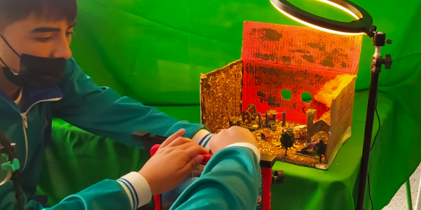 Niños organizando una maqueta con un foco de luz 