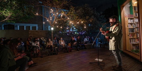 Hombre cantando en una librería en la noche