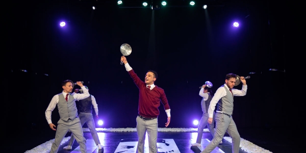 Escena de obra de teatro con jóvenes de colegio de pie