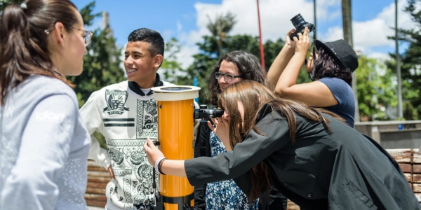 Personas al aire libre en actividad con telescopio