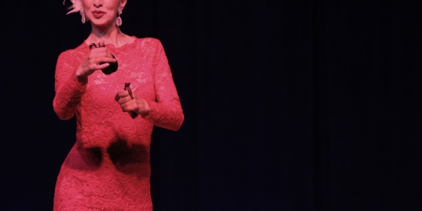 Mujer danzando en escenario con castañuelas