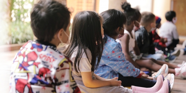 Fila de niños sentados en el piso