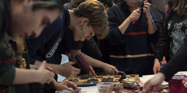 Un grupo de personas elaborando grabados sobre una mesa