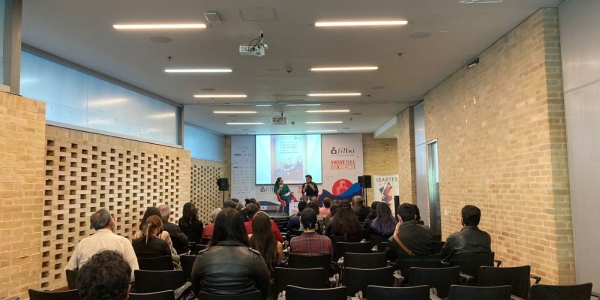 Salón con gente sentada escuchando una conferencia