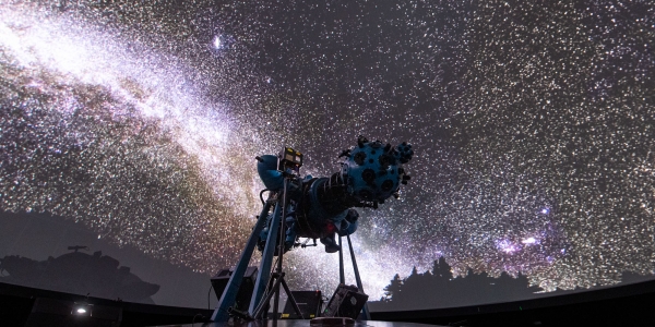 Proyector óptico mecánico en el domo con proyección del cielo de fondo. 