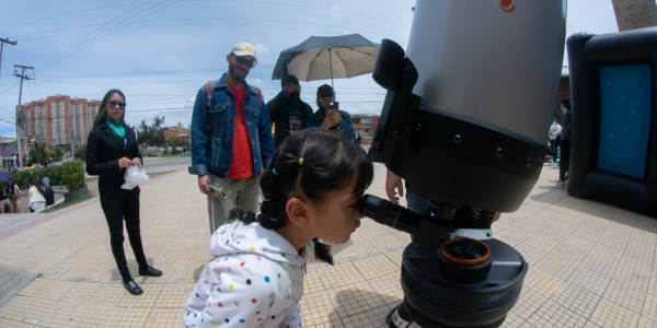 Imagen de niños observando por un telescopio 