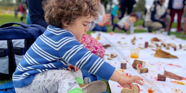 Niña jugando con fichas de madera y pintura en el parque